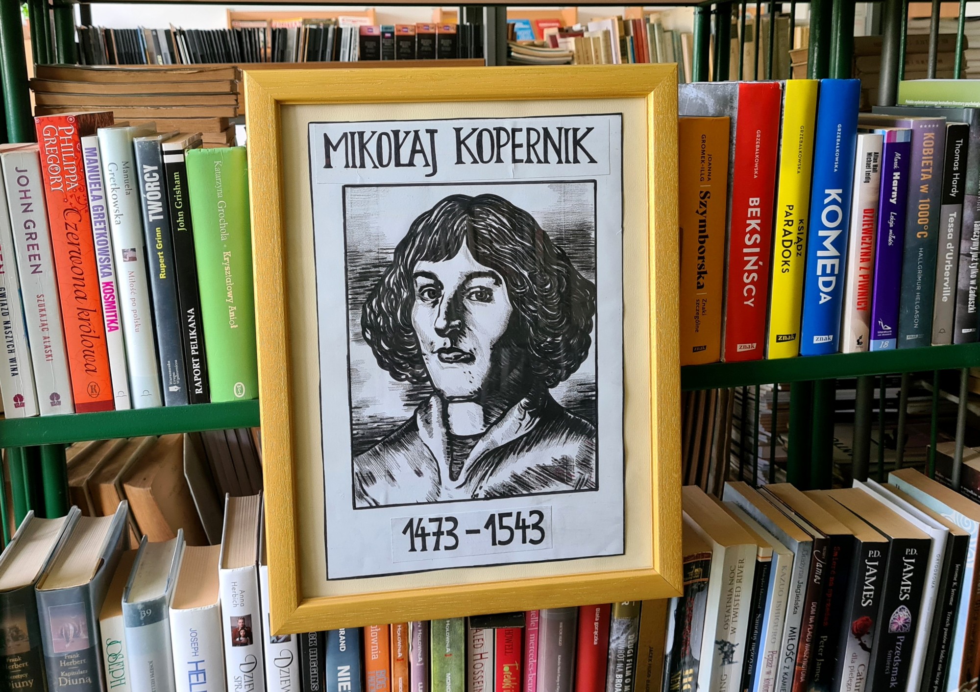książki i rysunek przedstawiający Mikołaja Kopernika 